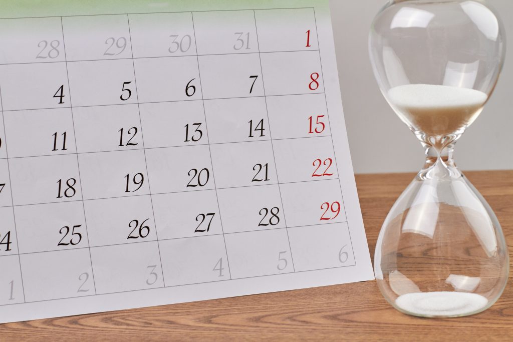 calendar sitting next to an hourglass