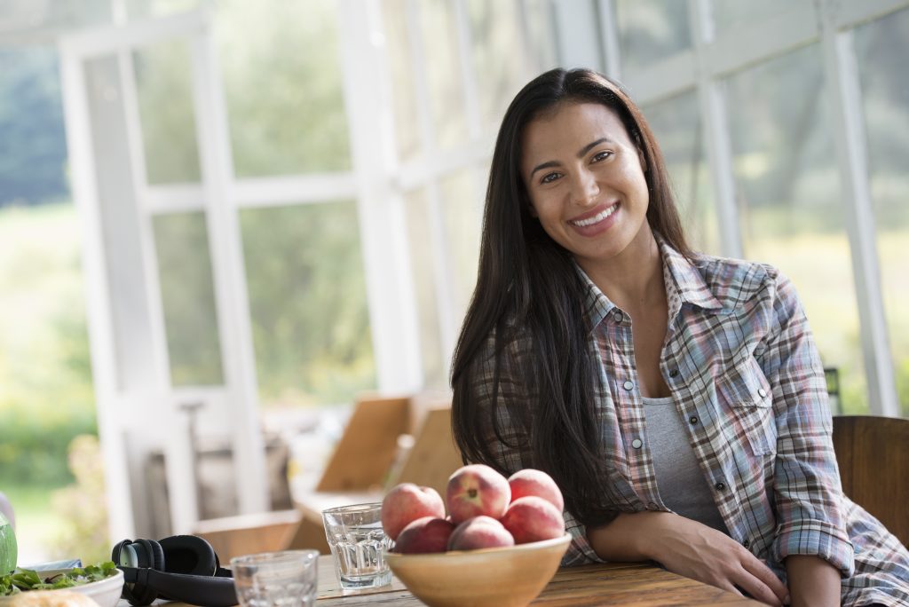 Happy hispanic woman in home kitchen